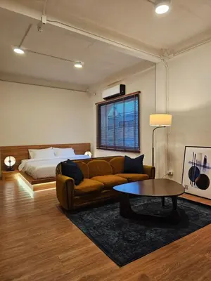 a living room with a couch and a bed at Yaowarat Stay in Bangkok
