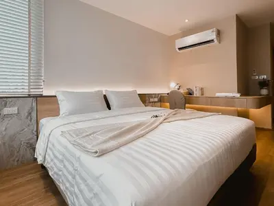 a bedroom with a large bed with white sheets at Townhouse PK Garden in Bangkok