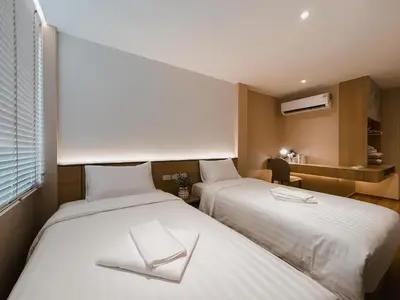 a room with two beds with white sheets at Townhouse PK Garden in Bangkok