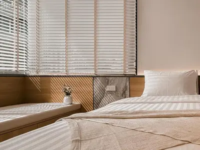 a bedroom with a bed and a window with blinds at Townhouse PK Garden in Bangkok