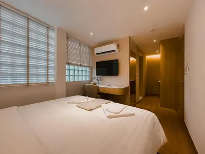 a bedroom with a large white bed and a sink at Townhouse PK Garden in Bangkok