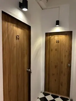 a bathroom with two wooden doors and a checkered floor at Thai Siwilai Hostel in Bangkok