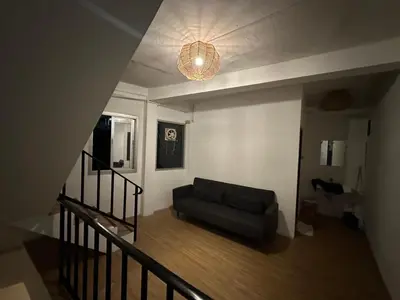 a living room with a couch and a chandelier at Thai Siwilai Hostel in Bangkok