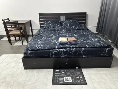 a bed with a black comforter in a bedroom at Muangthong p2 in Ban Song Hong