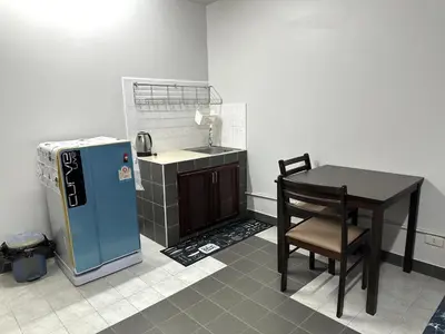 a small kitchen with a table and a blue refrigerator at Muangthong p2 in Ban Song Hong