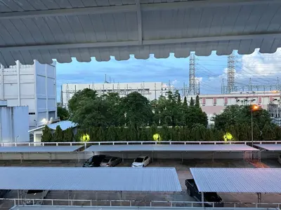 a parking lot with tables and chairs in a building at Muangthong p2 in Ban Song Hong