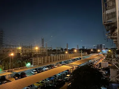 a parking lot filled with lots of cars at night at Muangthong p2 in Ban Song Hong