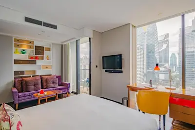 a hotel room with a large bed and a desk at Hotel Indigo Bangkok Wireless Road by IHG in Bangkok