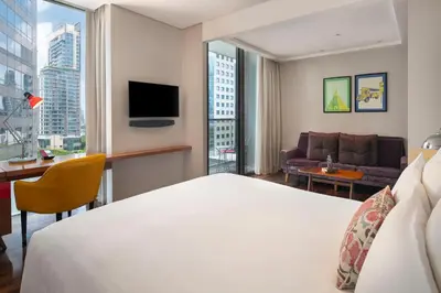 a hotel room with a bed and a large window at Hotel Indigo Bangkok Wireless Road by IHG in Bangkok