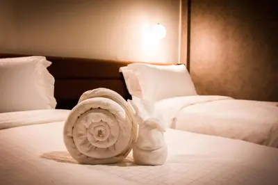 a towel on a bed in a hotel room at C U Inn Bangkok in Bangkok