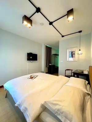 a bedroom with a large white bed with lights at C U Inn Bangkok in Bangkok
