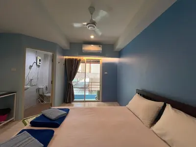 a bedroom with a large bed with a blue wall at Bonita House in Bangkok