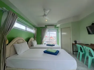 a bedroom with two beds and a window at Bonita House in Bangkok