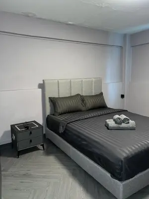 a bedroom with a large bed with a night stand at Inntown in Amphoe Phra Khanong