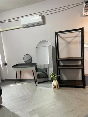 a room with a mirror and a desk and a table at Inntown in Amphoe Phra Khanong