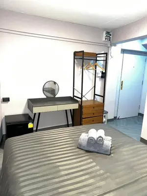 a bedroom with a bed and a sink and a mirror at Inntown in Amphoe Phra Khanong