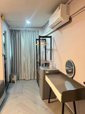 a room with a desk and a mirror in a room at Inntown in Amphoe Phra Khanong