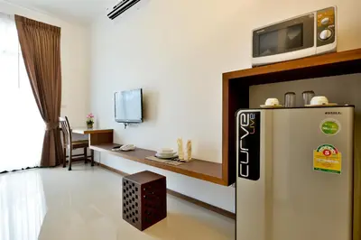 a living room with a tv on top of a refrigerator at The Choice Hotel - Adults Only in Bangkok