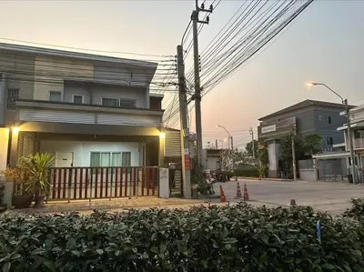 a building with a fence in front of a street at The Lake Guest House in Ban Bang Phang