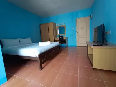 a bedroom with a bed and a tv and blue walls at jw place รามคำแหง 40 in Bangkok