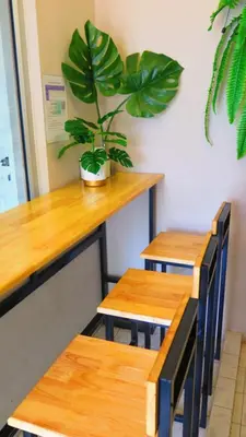a table and chairs with a potted plant in a room at Fall Asleep hotel in Nonthaburi