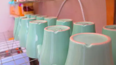 a bunch of green vases lined up on a rack at Fall Asleep hotel in Nonthaburi