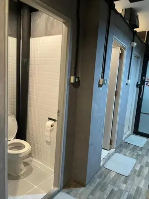 a bathroom with a toilet and a glass door at Brio Cafe and Hostel in Godown