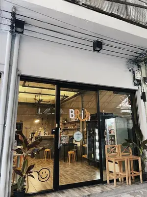a store front with glass doors and wooden chairs at Brio Cafe and Hostel in Godown