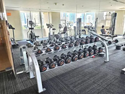 a gym with a rack of dumbbells in a gym at Sathorn prime Panorama City View rooftop bar in Bangkok