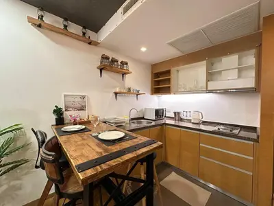 a kitchen with a wooden table and a counter at Sathorn prime Panorama City View rooftop bar in Bangkok