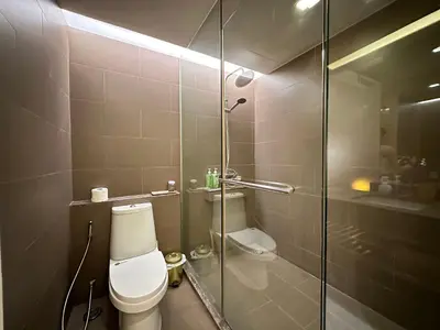 a bathroom with a toilet and a glass shower at Sathorn prime Panorama City View rooftop bar in Bangkok