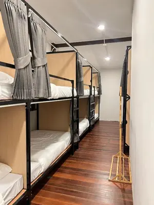 a room with four bunk beds and a wooden floor at House Ju in Bangkok