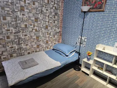 a room with a small bed in a brick wall at 211 Spacious studio with breezy fan full amenities with free Wi-Fi in Bangkok
