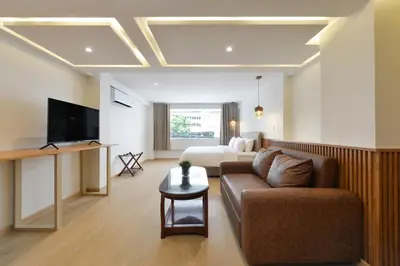 a living room with a couch and a bed at Ratchathewi Hyde Away in Pratunam