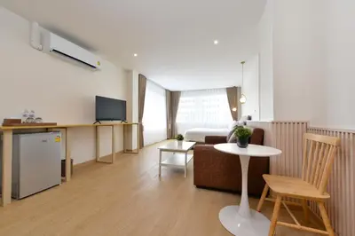 a living room with a couch and a table at Ratchathewi Hyde Away in Pratunam