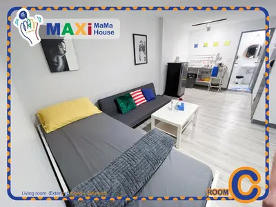 a room with a bed and a couch and a table at MAXi MaMa House in Bangkok