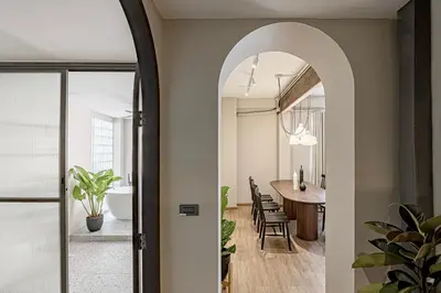 an archway leads into a dining room with a dining table at The Lair Bangkok - 3mins walk to ICON SIAM in Bangkok