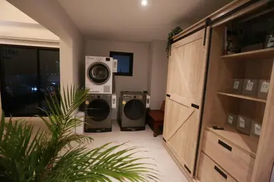 a laundry room with two washers and a dryer at BaanTip​ HomeStay in Amphoe Phra Khanong