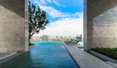 a swimming pool with a view of a city at Modern condo nr BTS ONNUT WIFI in Bangkok