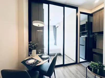 a dining room with a table and a room with a bedroom at Modern condo nr BTS ONNUT WIFI in Bangkok