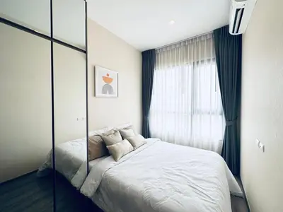 a bedroom with a large bed and a window at Modern condo nr BTS ONNUT WIFI in Bangkok