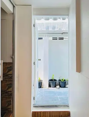 a door with three potted plants inside of it at Chubby 5 Room 4 in Ban Bang Bamru