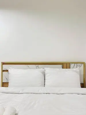 a bed with white sheets and pillows on it at Chubby 5 Room 4 in Ban Bang Bamru