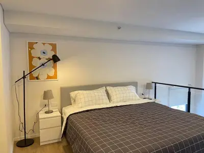 a bedroom with a bed and a lamp on a night stand at Siamese 87 2BR \u7d20\u5764\u9038 BTS On Nut LOFT \u4e24\u623f 25 in Bangkok