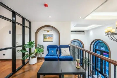 a living room with a table and blue chairs at Cherie Bangkok Boutique Hotel in Bangkok