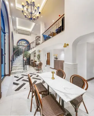 a dining room with a table and chairs and a staircase at Cherie Bangkok Boutique Hotel in Bangkok