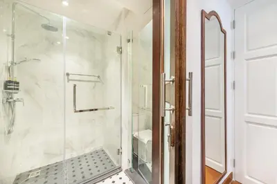 a bathroom with a shower with a glass door at Cherie Bangkok Boutique Hotel in Bangkok