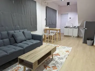 a living room with a blue couch and a table at Cloud9 Hometel - Entire House 3BR 170m to BTS Private Quiet & Comfy in Bangkok