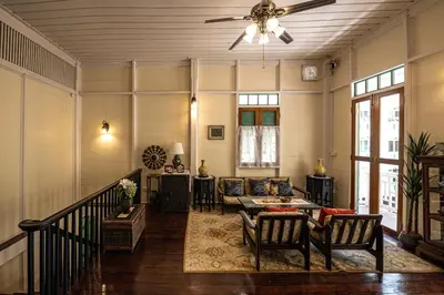 a living room with a couch and a ceiling fan at Wallaya Heritage Stay in Bangkok