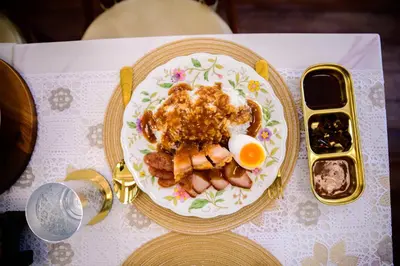a plate of food with an egg on a table at Wallaya Heritage Stay in Bangkok